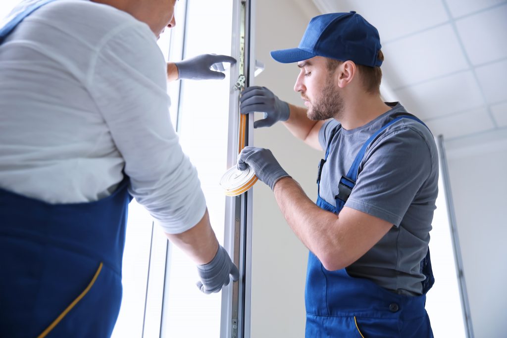 Men replacing weatherstripping