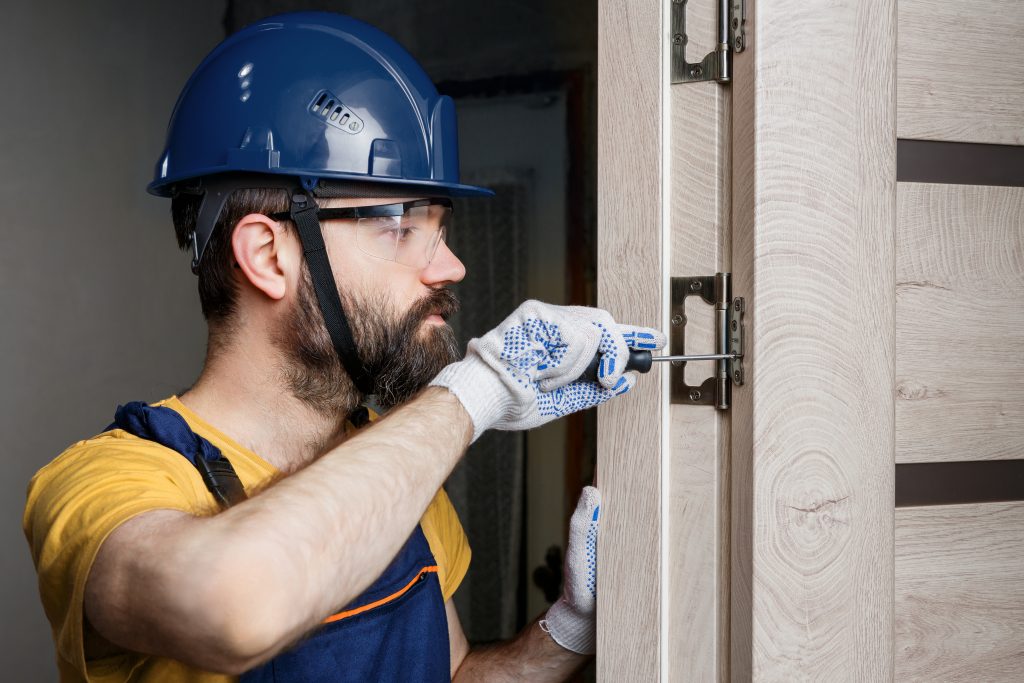 man repairing commercial door frame